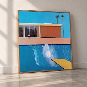 Puede incluir: Una impresión de arte mural enmarcada que representa una casa moderna de mediados de siglo con techo plano, un gran ventanal y un patio. En primer plano, una piscina azul brillante cuenta con un trampolín amarillo y una gran salpicadura.