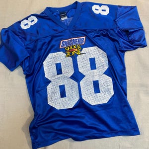 May include: A blue mesh football jersey with the number 88 in white on the front and shoulders. The jersey has the text "Snickers Shock Zone" across the chest.