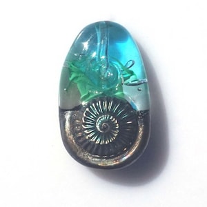 May include: A white ceramic mug with a black handle and the text "But First, Coffee" in a bold, black font. The mug is set against a blurred background, suggesting a cozy setting.