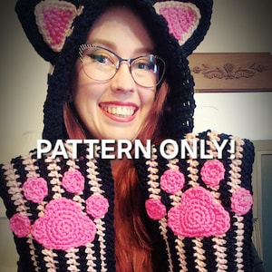 May include: A black and pink crochet cat ear hood with a matching scarf featuring pink paw prints. The text "PATTERN ONLY!" is displayed on the image. The hood and scarf are handmade.