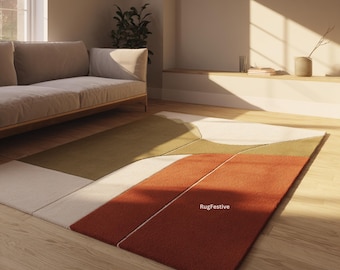 Puede incluir: Alfombra moderna con diseño geométrico en tonos óxido, verde oliva y crema. La alfombra presenta bloques de color angulados y el texto "RugFestive". Está colocada sobre un suelo de madera. El diseño de la alfombra añade un toque contemporáneo a la habitación.