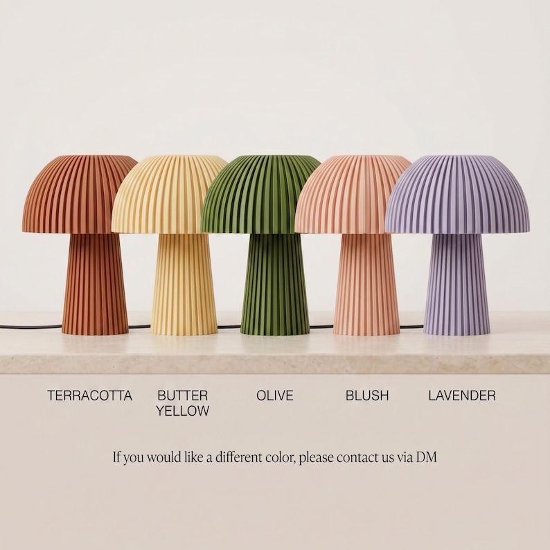Puede incluir: Cinco l&aacute;mparas de mesa con forma de seta y textura acanalada vertical, dispuestas en fila. Los colores de izquierda a derecha son terracota, amarillo mantequilla, oliva, rubor y lavanda. El texto bajo cada l&aacute;mpara identifica el color, y una nota dice: If you would like a different color, please contact us via DM.