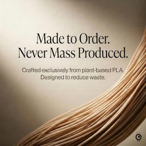 K&ouml;nnte beinhalten: Eine Spule aus hellbraunem, pflanzlichem PLA-Filament mit dem Text: Made to Order. Never Mass Produced. Crafted exclusively from plant-based PLA. Designed to reduce waste. Ein kleines kreisf&ouml;rmiges Logo mit einem Gesicht ist unten rechts.