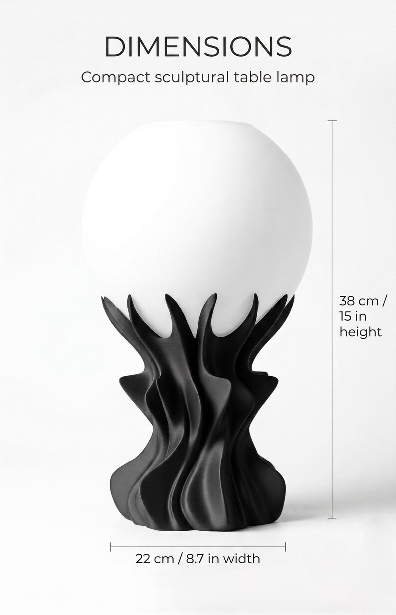 May include: A compact sculptural table lamp with a white globe shade and a black, stylized base. The lamp is 15 inches in height and 8.7 inches wide. The image includes the word "DIMENSIONS".