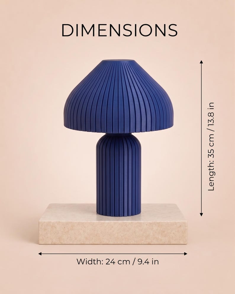 May include: A dark blue mushroom-shaped lamp with a vertically ribbed texture. The lamp stands on a rectangular beige base. Text indicates dimensions of 35 cm / 13.8 in in length and 24 cm / 9.4 in in width. The word DIMENSIONS is at the top.