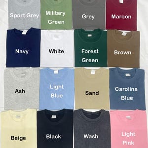 May include: A collection of various colored t-shirts, including Sport Grey, Military Green, Grey, Maroon, Navy, White, Forest Green, Brown, Ash, Light Blue, Sand, Carolina Blue, Beige, Black, Wash, and Light Pink. Each shirt has a crew neck.