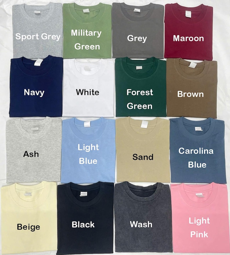 May include: A collection of various colored t-shirts, including Sport Grey, Military Green, Grey, Maroon, Navy, White, Forest Green, Brown, Ash, Light Blue, Sand, Carolina Blue, Beige, Black, Wash, and Light Pink. Each shirt has a crew neck.