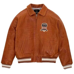 May include: A brown leather jacket with a crocodile texture. The jacket has a zipper closure, a collar, and a patch on the chest with the text "AVIREX". The cuffs and hem have white and brown stripes.