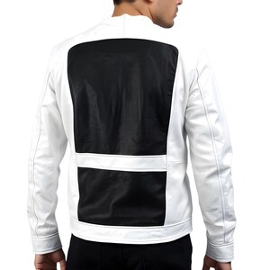 May include: A white jacket with a black panel on the back. The jacket has a stand-up collar and long sleeves. A horizontal white stripe accents the black panel. The jacket appears to be made of a leather-like material.