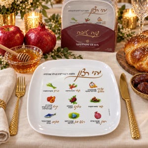 May include: A white square serving tray featuring colorful illustrations of various foods and Hebrew text. The tray displays nine distinct icons representing traditional Rosh Hashanah symbols, each accompanied by its corresponding Hebrew name and prayer.