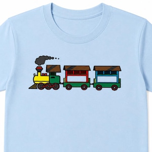 May include: Light blue t-shirt featuring a cartoon train illustration. The train has a yellow engine, green cars, and red and blue roofs. Black smoke billows from the engine's smokestack. The design is outlined in black.