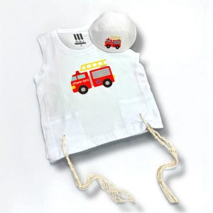 Peut inclure: Ensemble blanc composé d'un t-shirt sans manches et d'une kippa assortie, orné d'un motif de camion de pompiers rouge et jaune. Le t-shirt a deux poches et des cordons noués. La kippa est blanche avec un petit motif de camion de pompiers.