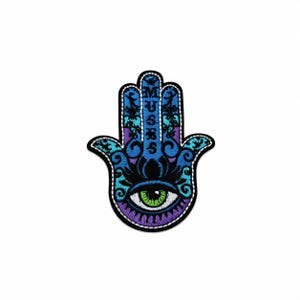 Könnte beinhalten: Ein gestickter Hamsa-Hand-Aufnäher mit einem zentralen grünen Auge und schwarzen Wimpern. Das Design enthält Blau-, Lila- und Schwarztöne mit komplexen Wirbelmustern. Das Wort MUSER ist vertikal in Weiß auf dem Mittelfinger eingestickt.