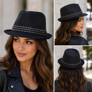 Puede incluir: Un sombrero fedora negro con ala ancha y una banda decorativa adornada con varias filas de pequeños tachones metálicos de color plateado. El sombrero tiene una copa estructurada con una hendidura central y acabado mate.