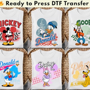 May include: White t-shirts featuring cartoon characters Mickey Mouse, Donald Duck, Goofy, Daisy Duck, and Pluto. Each shirt has a unique design with character names and dates. The text "Ready to Press DTF Transfer" is at the top.
