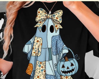 May include: A light blue patchwork ghost design with a bow and a pumpkin bucket. The ghost has large black eyes and is holding a blue pumpkin with a carved face. The text at the top says "Ready to Press DTF Transfer".