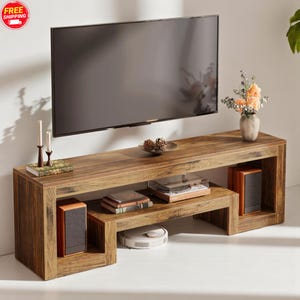 May include: A wooden TV stand with a rectangular design. The stand has a lower shelf with a turntable and books, and two speaker cabinets. A TV is mounted above the stand, and decorative items like candles and a vase with flowers are placed on top.