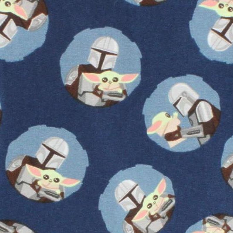 May include: A repeating pattern on a navy blue background features illustrations of a Mandalorian character holding a small, green creature with large ears. The illustrations are set within light blue circles, creating a playful and thematic design.