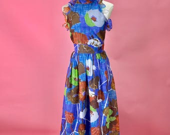 May include: A sleeveless floor-length dress featuring a vibrant blue background with a large-scale floral print in shades of brown, green, orange, and white. The garment includes a high ruffled neckline, a defined waistline, and a ruffled hemline.