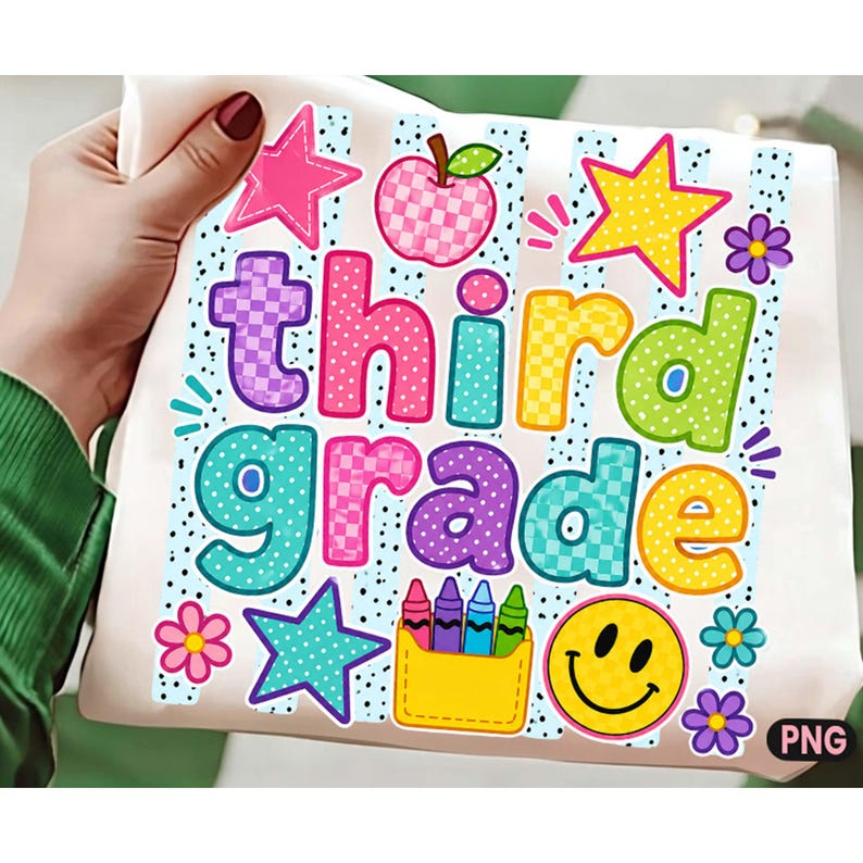 May include: A white fabric surface featuring a colorful graphic with the text "third grade" in bubble letters. The design includes a checkered apple, stars, flowers, a smiley face, and a yellow pocket containing five crayons on a dotted background.