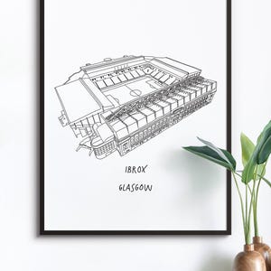 May include: Black framed art print featuring a detailed line drawing of Ibrox Stadium in Glasgow. The stadium is depicted in a three-dimensional perspective, with the text "IBROX GLASGOW" below the image. The artwork is displayed on a white background.