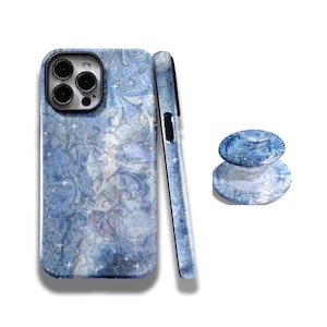 May include: A blue phone case with a swirling marble-like pattern and small white star accents, shown from the back and side, accompanied by a matching circular collapsible phone grip with the same blue marbled design and white star details.