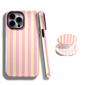 Puede incluir: Un conjunto de accesorios para teléfono con un diseño de rayas rosas y amarillas. El conjunto incluye una funda para teléfono, un agarre para teléfono y una funda para teléfono. La funda del teléfono tiene un área de lente de cámara negra. El agarre del teléfono es redondo y tiene una base transparente.