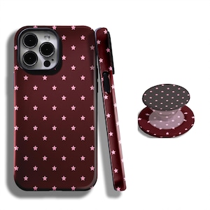 May include: A maroon phone case, a matching phone grip, and a phone case side view. All three items have a repeating pattern of small pink stars. The phone case has a black camera lens area.