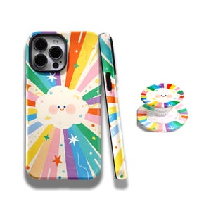 May include: A colorful phone case and matching pop socket featuring a cheerful cloud design with a rainbow burst background. The case and pop socket have a glossy finish and are decorated with stars.