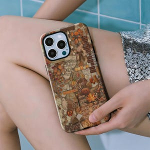 Può includere: Una custodia per telefono con un design a tema autunnale. La custodia presenta un collage di elementi autunnali, tra cui zucche, foglie e testo. La tavolozza dei colori include toni caldi di marrone, arancione e beige, con un tocco di verde. Il testo sulla custodia recita "Fall is here".