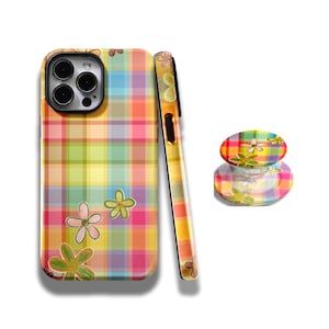 May include: A colorful phone case, phone grip, and matching phone case side panel. The case and grip feature a plaid pattern in shades of pink, yellow, green, and orange, with floral accents. The phone case side panel is a gradient of yellow to orange.