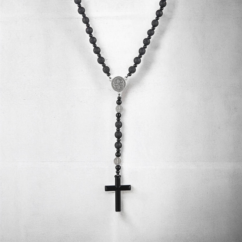 Puede incluir: Collar de rosario negro con cuentas redondas y oscuras y un colgante de cruz negro. El collar incluye una pieza central plateada y cuentas m&aacute;s peque&ntilde;as. Las cuentas tienen aproximadamente 0,8 cm de di&aacute;metro.