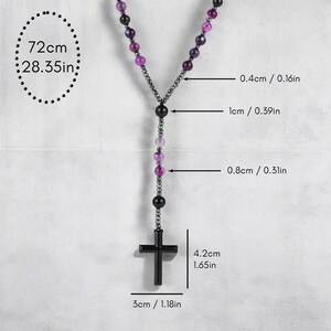 May include: A rosary necklace with purple and black beads and a black cross pendant. The necklace is 72cm (28.35in) long, with the cross measuring 4.2cm (1.65in) high and 3cm (1.18in) wide. The beads are 0.4cm (0.16in), 1cm (0.39in), and 0.8cm (0.31in) in diameter.