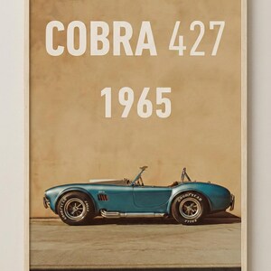 Puede incluir: Impresi&oacute;n enmarcada de un coche descapotable Cobra 427 azul de 1965. El coche est&aacute; aparcado sobre una superficie de hormig&oacute;n, con un fondo beige. Las palabras "COBRA 427" y "1965" est&aacute;n en texto blanco en la parte superior.