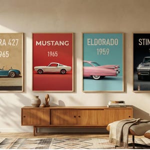 Könnte beinhalten: Vier gerahmte Poster mit klassischen Autos: Cobra 427 (1965), Mustang (1965), Eldorado (1959) und Sting Ray (1963). Jedes Poster hat einen farbigen Hintergrund mit dem Namen und dem Jahr des Autos. Die Poster werden über einem Holzschrank ausgestellt.