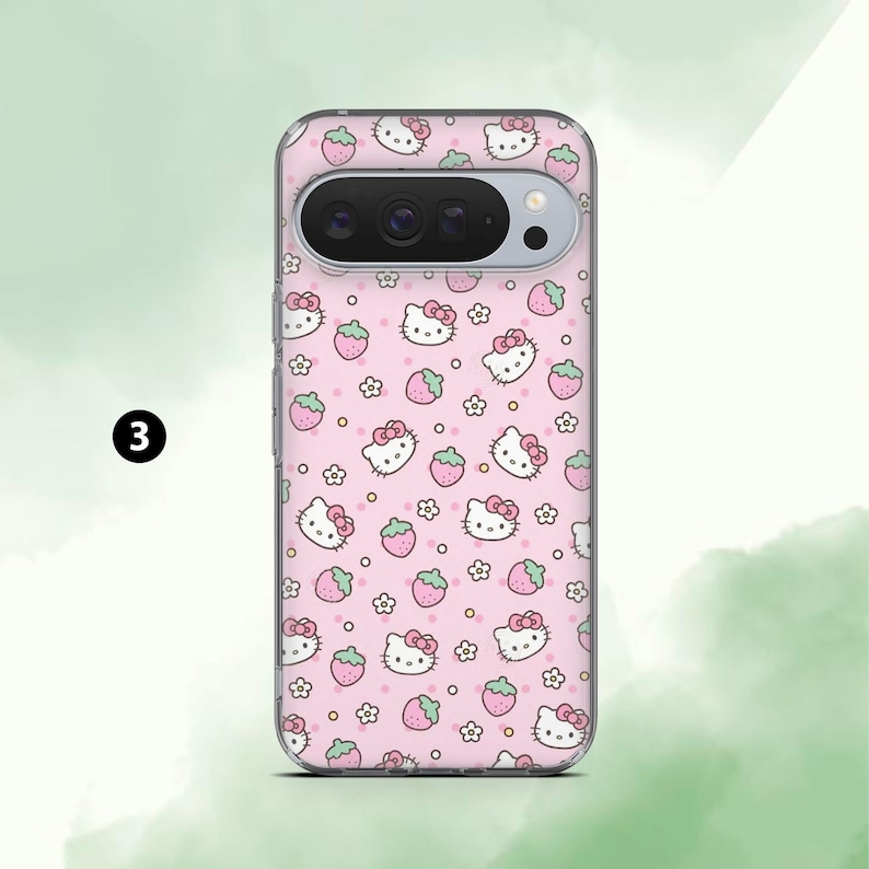May include: A pink phone case featuring a repeating pattern of Hello Kitty faces, strawberries, and small white flowers. The case has a clear border and a camera cutout. The number "3" is in a black circle in the upper left corner.