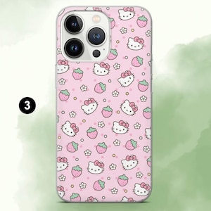 Puede incluir: Una funda de tel&eacute;fono rosa con un patr&oacute;n repetido de caras de Hello Kitty, fresas y flores. La funda tiene un borde transparente y un recorte para la c&aacute;mara. El n&uacute;mero "3" es visible en un c&iacute;rculo negro en el lado izquierdo.
