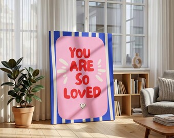 May include: A framed canvas art print with the words "YOU ARE SO LOVED" in red letters on a pink background. The artwork is framed with blue and white stripes and includes a small heart symbol.