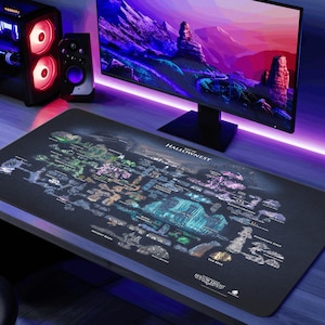 Może przedstawiać: Duża, czarna podkładka pod mysz z szczegółową mapą Hallownest, z białymi etykietami. Podkładka jest prostokątna i leży na biurku, z monitorem komputera i wieżą w tle. Mapa ma kolorowy design.
