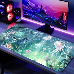 May include: A rectangular gaming mouse mat with an underwater design featuring jellyfish, bubbles, and a stylized character. The mat is teal and green, with a computer monitor and tower in the background.
