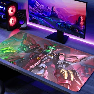 May include: Large rectangular gaming mouse pad featuring a detailed illustration of a red, green, and gold robot. The mouse pad is on a desk with a computer monitor, computer tower, and speakers. The desk is illuminated with purple and green lights.