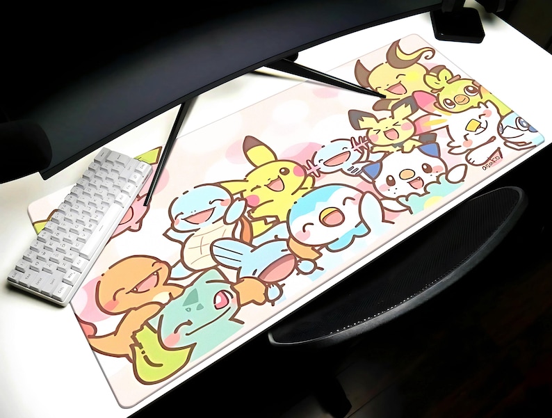 A colorful mouse pad featuring various cartoon Pokemon characters, including Pikachu, Charizard, Bulmer, and others, is placed on a desk alongside a keyboard and a mouse.