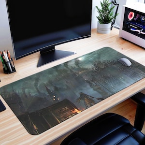 Puede incluir: Una alfombrilla de ratón rectangular grande con una ilustración oscura de fantasía. La obra de arte representa un paisaje urbano gótico con una figura en primer plano. La paleta de colores está dominada por tonos de gris, verde y naranja.