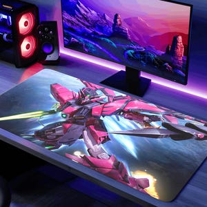 May include: A large rectangular gaming mousepad featuring a detailed illustration of a pink and gray mecha robot with a green energy beam. The background has a space-themed design with blue and white hues.
