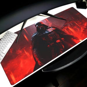 Könnte beinhalten: Rechteckiges Gaming-Mauspad mit Darth Vader in einer rot-schwarzen Szene. Das Pad liegt auf einem weißen Schreibtisch mit einer weißen Tastatur und einem schwarzen, gebogenen Monitor.