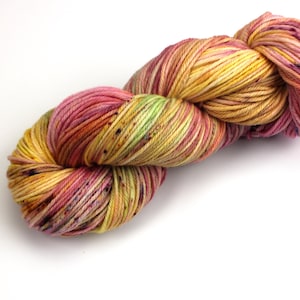 May include: A skein of colorful yarn in shades of yellow, pink, and green. The yarn is tightly wound and has a speckled appearance. Ideal for knitting or crocheting projects.
