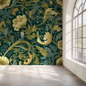 Op de afbeelding: Een kamer met een donkerblauwe bloemenbehang met grote, gestileerde bloemen en bladeren in goud- en groentinten. Het behang bedekt de muur en de kamer heeft een betonnen vloer en een groot boogvormig raam.