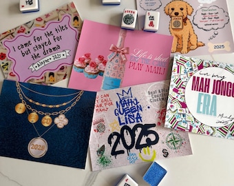 May include: A collection of Mahjong-themed items, including tiles, cards, and decorative elements. The cards feature text like "I came for the tiles but stayed for the drama" and "Life is short eat the cake play Mahj".
