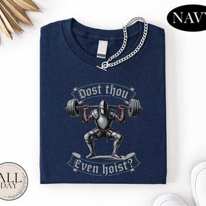 a navy blue t-shirt with a graphic design depicting a knight lifting a barbell, accompanied by the text "Do you think even hoist?"