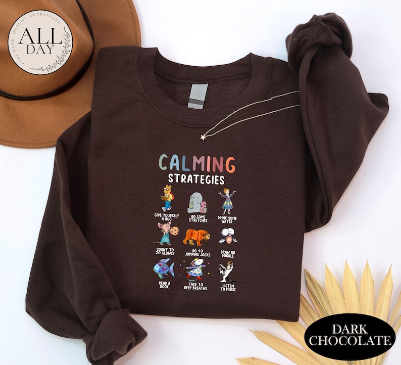 a brown sweatshirt with a colorful graphic design on it, along with a hat and some decorative elements.